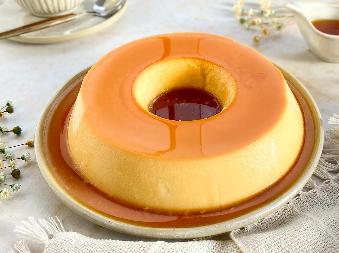 Pudim de quatro leites com calda brilhante de caramelo em um prato